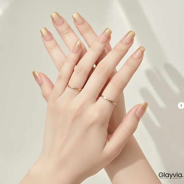 Both hands showing elegant gold glitter gradient nails with glossy nude base manicure