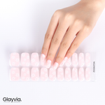 Hand wearing Glayvia NG200032 soft daisy blush semi cured gel nail wraps displayed above matching pale pink daisy floral nail wrap sticker sheet