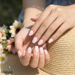 Lifestyle image of Glayvia NG200032 soft daisy blush semi cured gel nail wraps with pale pink floral manicure holding straw summer hat