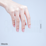 Hand wearing Glayvia NG200052 natural sheer gloss semi cured gel nail wraps displayed above matching transparent natural nail wrap sticker sheet