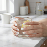 Silky Pearls pearlescent semi cured gel nail wraps with iridescent chrome finish styled in a bright kitchen setting holding a glass.